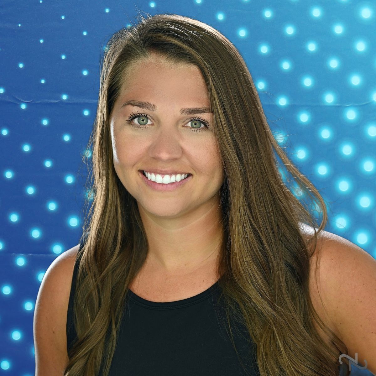 Smiling woman in a black top against a blue starry background