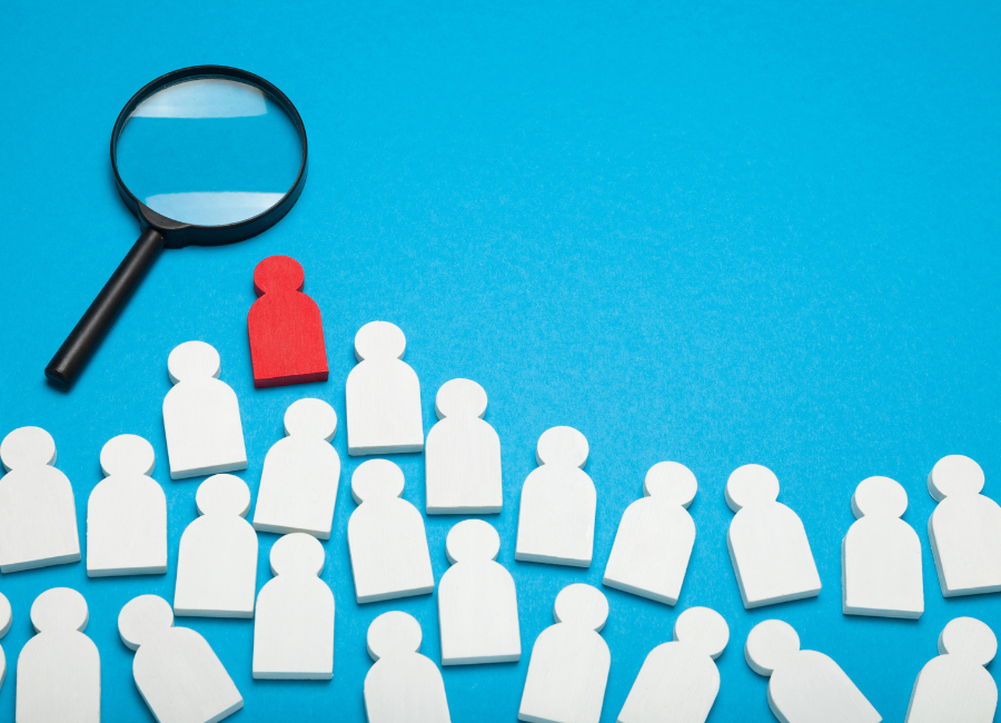 Glowing white figure surrounded by darker figures, standing out in a group on a dark background