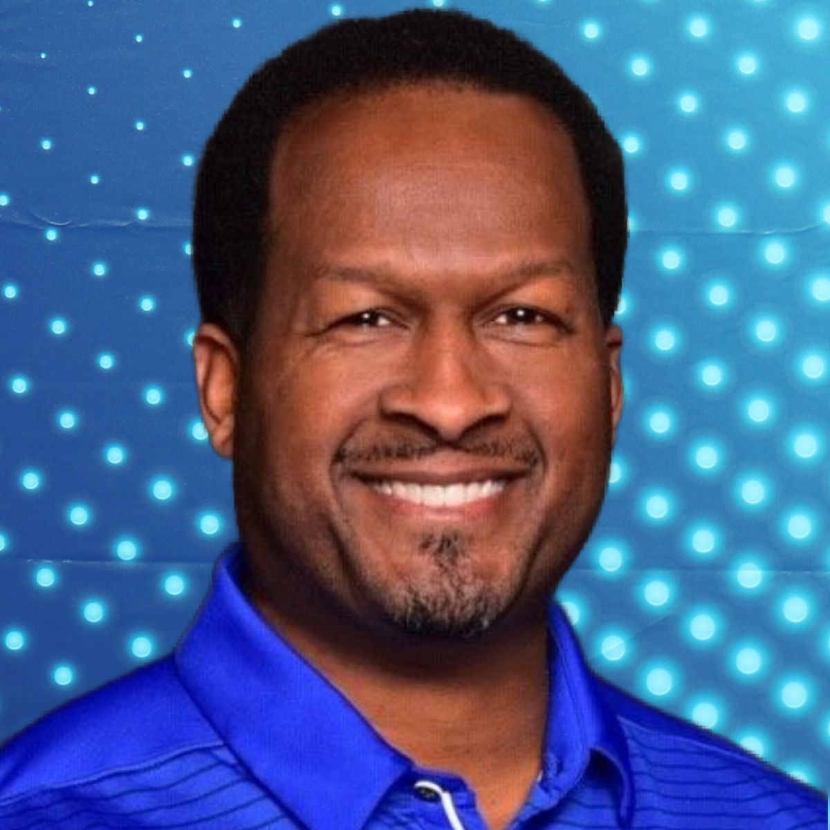 Smiling man in a blue shirt against a blue dotted background