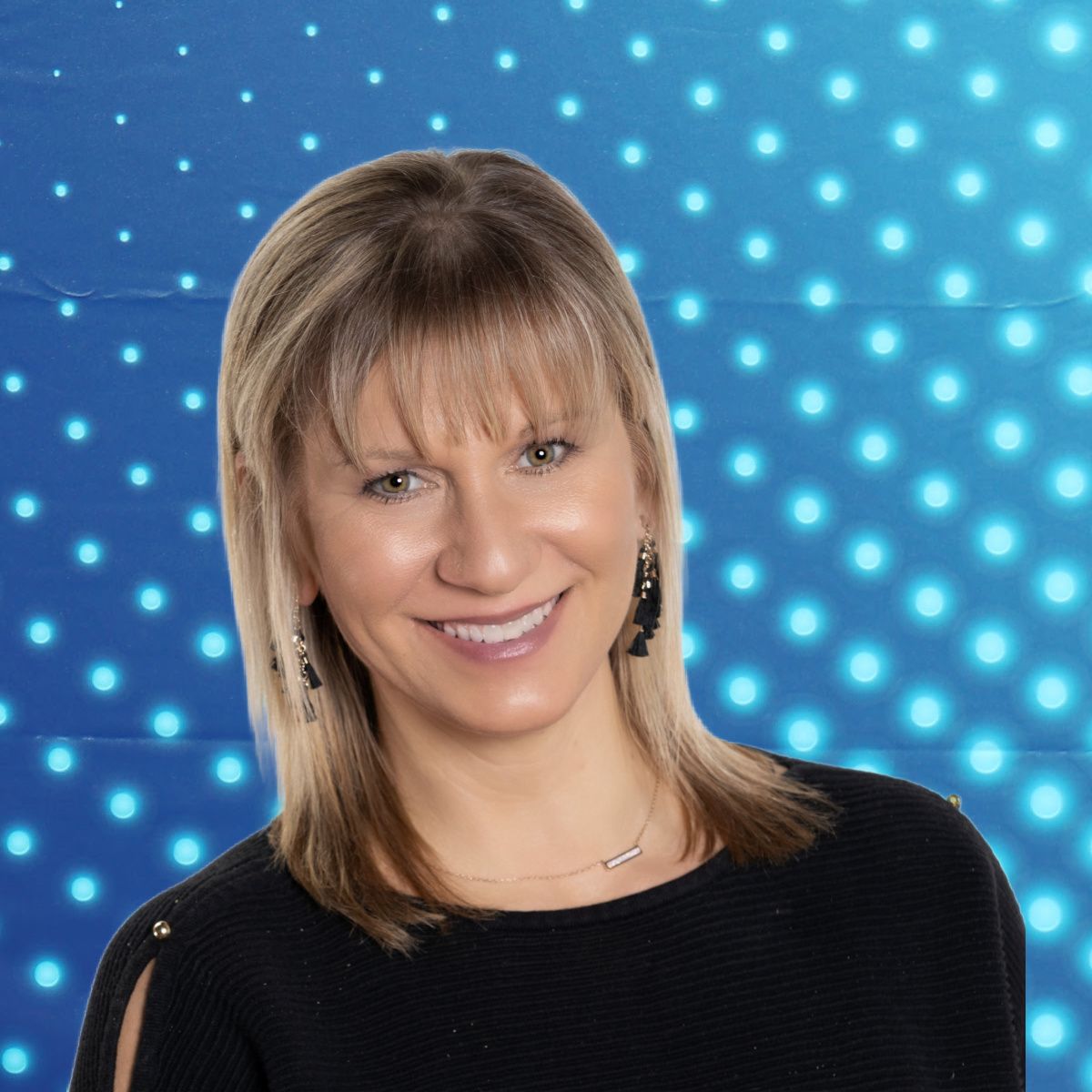 Portrait of a smiling woman against a blue dotted light background
