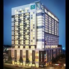 Modern multi-story hotel building lit up at night against a dark blue sky