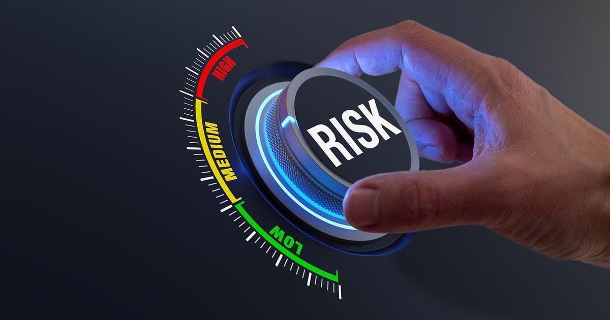 Hand turning a dial labeled “RISK” with a red-yellow-green risk meter