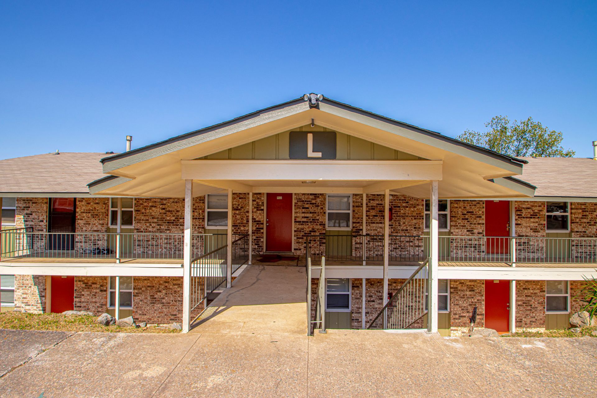 Two-story brick apartment building with a covered entrance marked with an