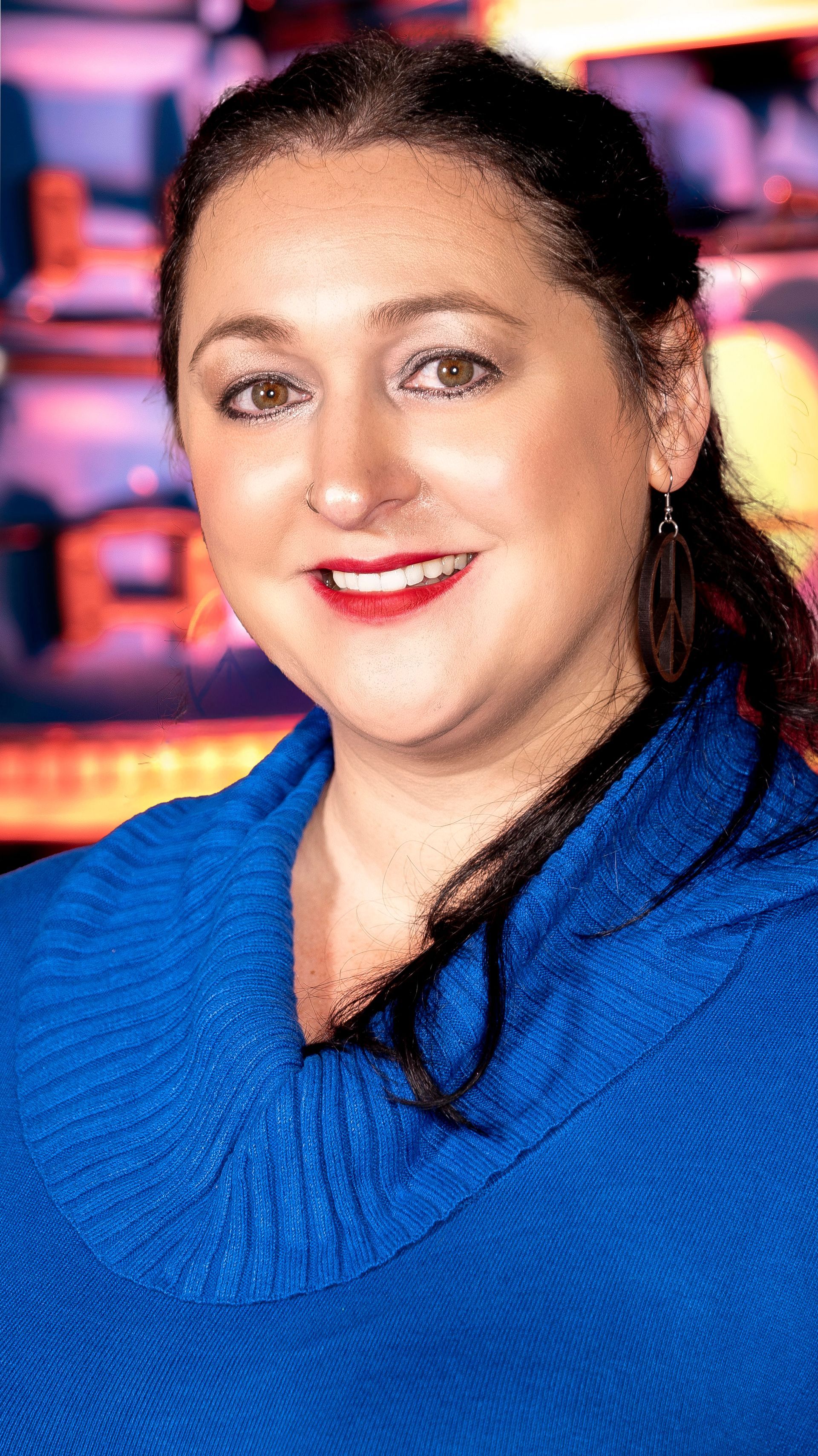 A woman wearing a blue sweatshirt is smiling for the camera.