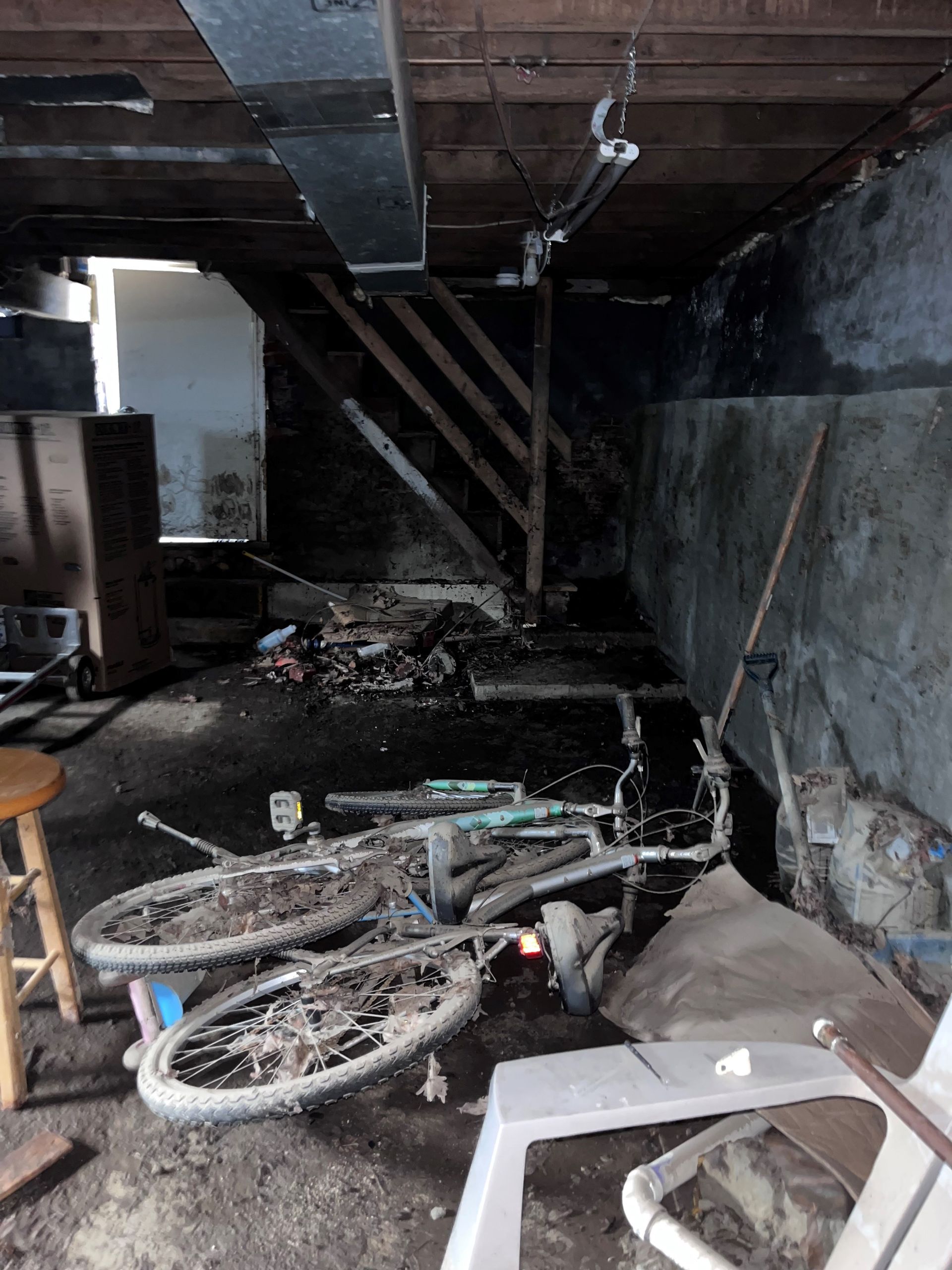A bicycle is laying on the ground in a basement