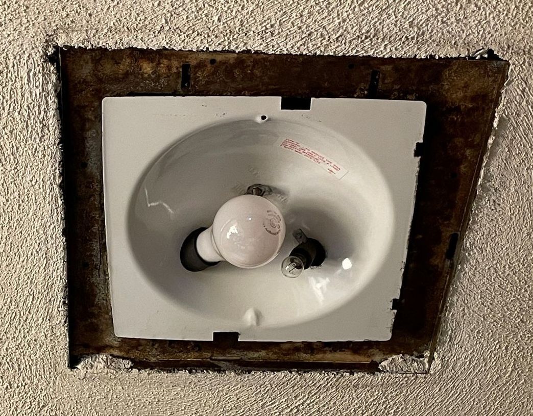 A light bulb is sitting in a hole in the ceiling.