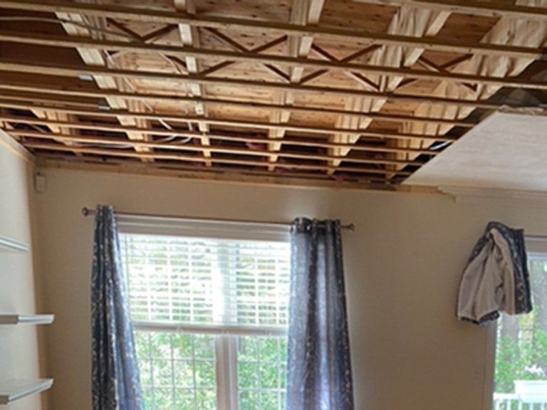 A room with a ceiling that is missing and a window.