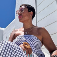 Woman wearing glasses and a striped top looking off to the side, outdoors.