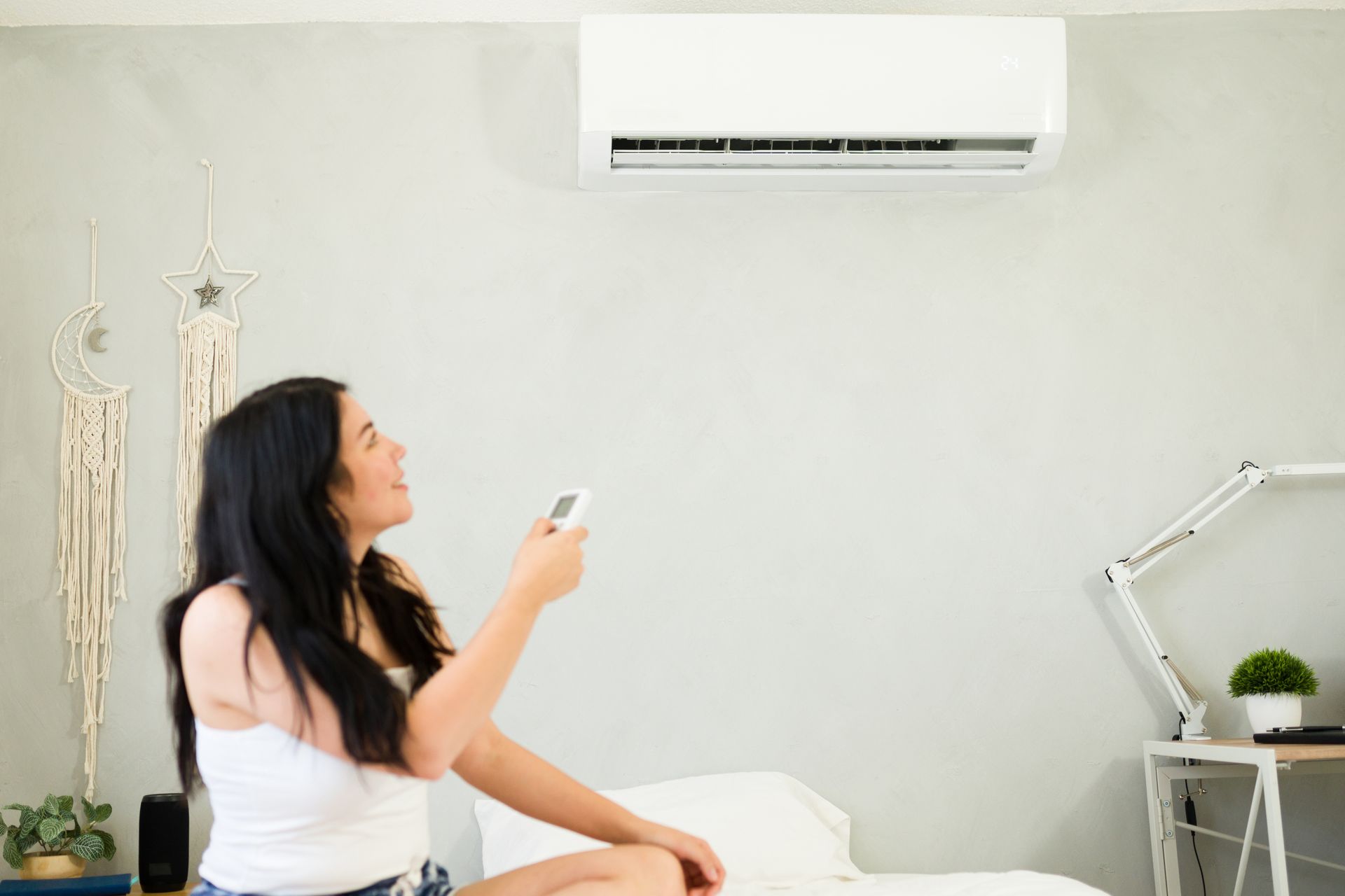 woman adjusting the ac unit temperature with the remote control woman adjusting the ac unit temperature with the remote control