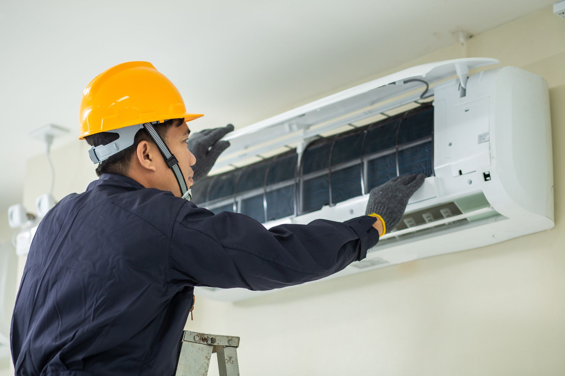 HVAC repair by technician indoors, expert air conditioning maintenance contractor.