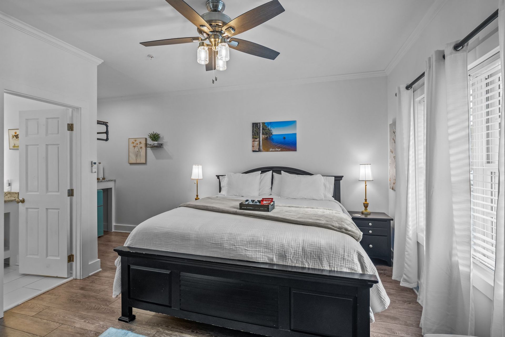 A bedroom with a king size bed and a ceiling fan.