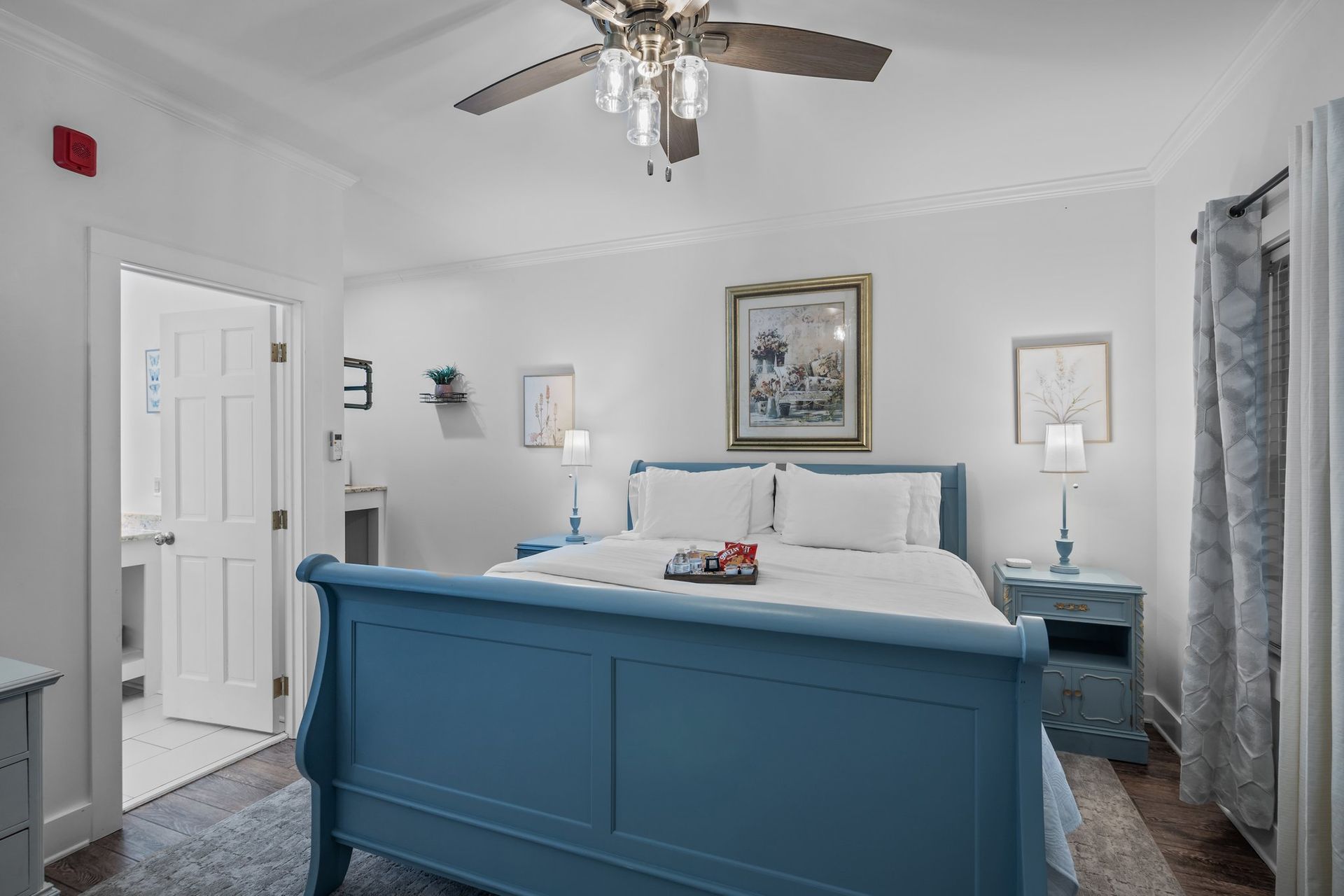 A bedroom with a blue sleigh bed and a ceiling fan.