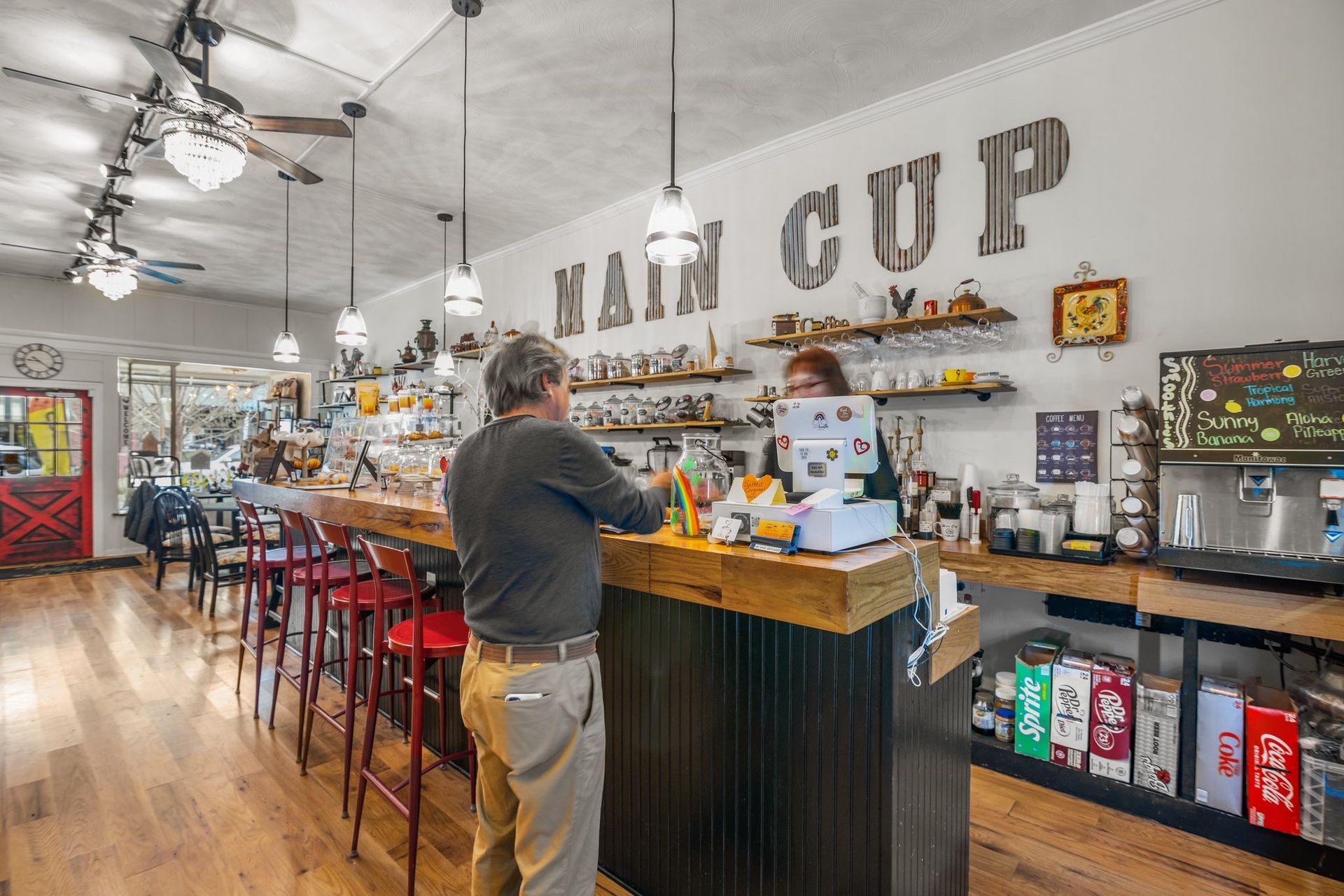 A man is standing at a counter in a restaurant.