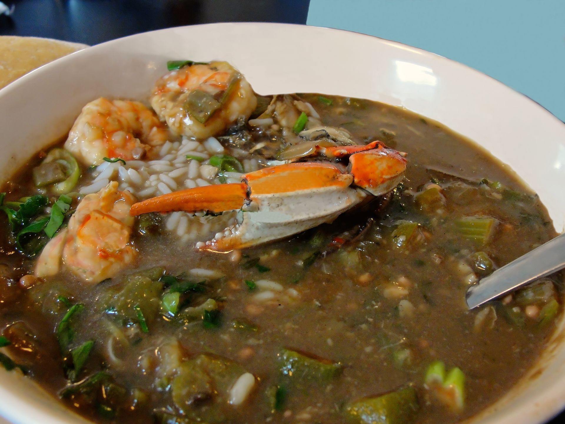 A bowl of soup with shrimp and crab on top
