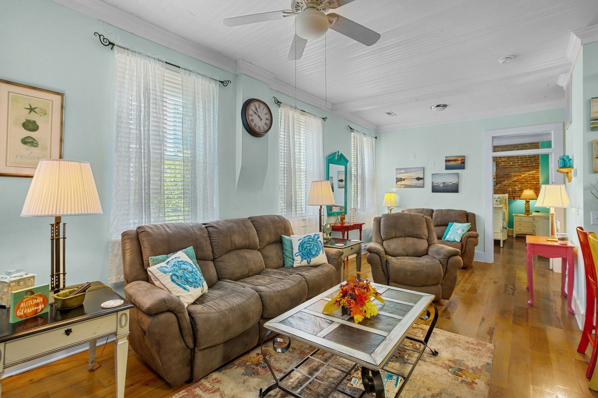 A living room filled with furniture and a ceiling fan.