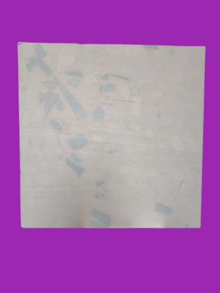 Una sábana cuadrada blanca con tenues marcas azules sobre un fondo morado.