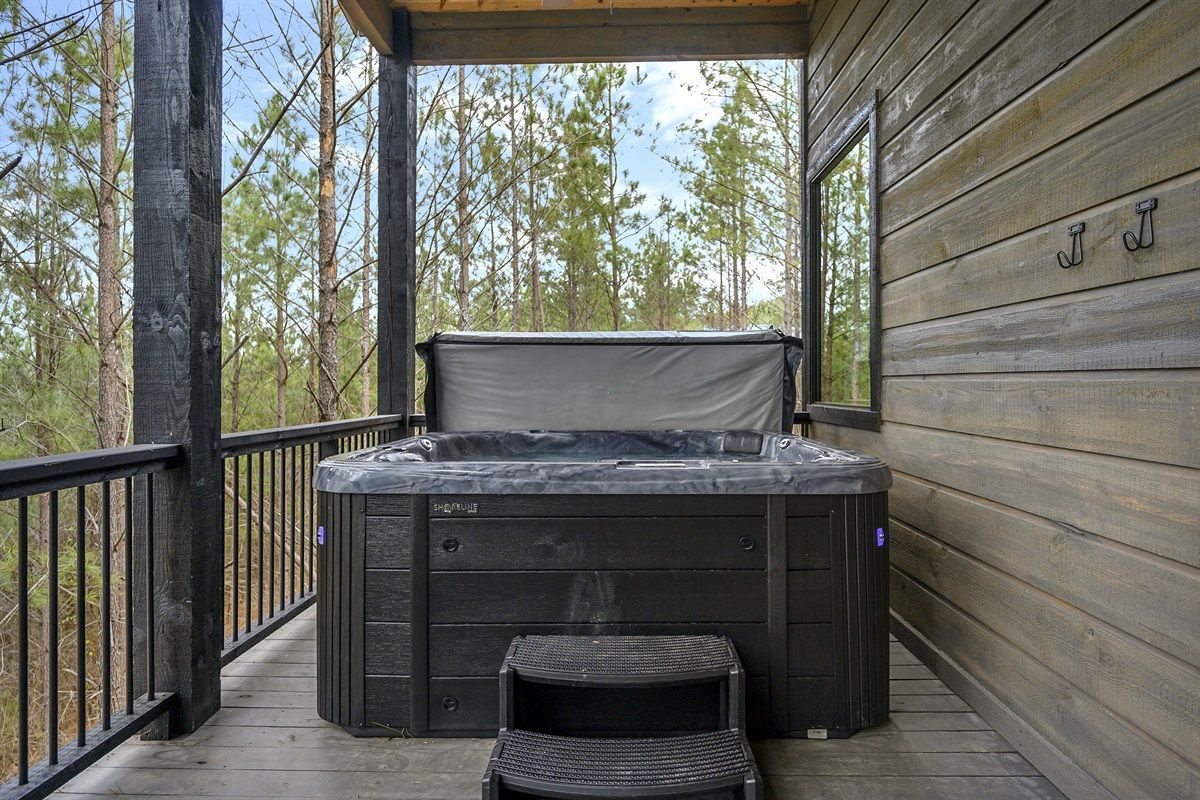 There is a hot tub on the porch of a cabin.