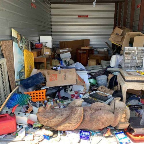 A storage shed filled with lots of junk and boxes.
