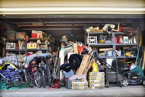 A garage filled with lots of junk and bicycles.