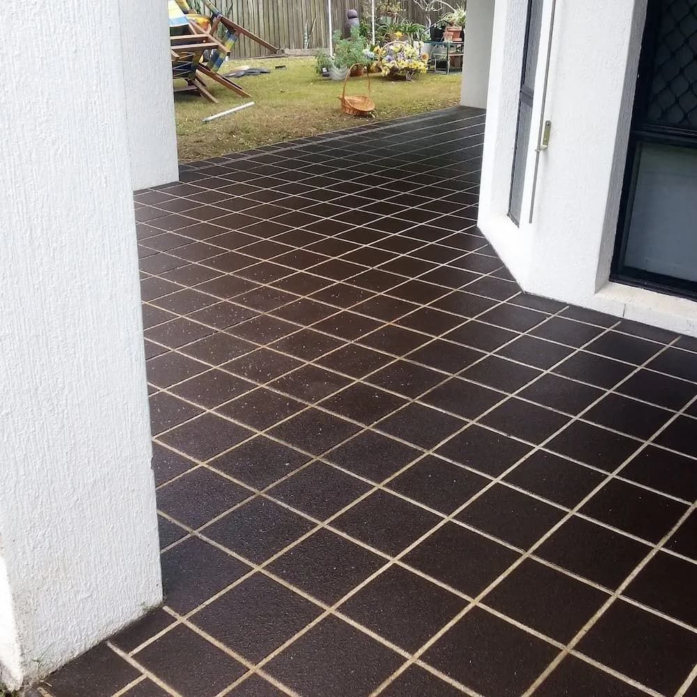 A Patio With a Black Tile Floor and White Lines — Troys Concrete Overlays in Hillcrest, QLD
