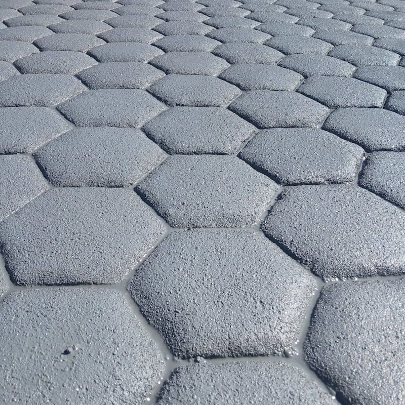 Grey hexagonal textured concrete in a repeating pattern viewed from ground level — Troys Concrete Overlays in Hillcrest, QLD