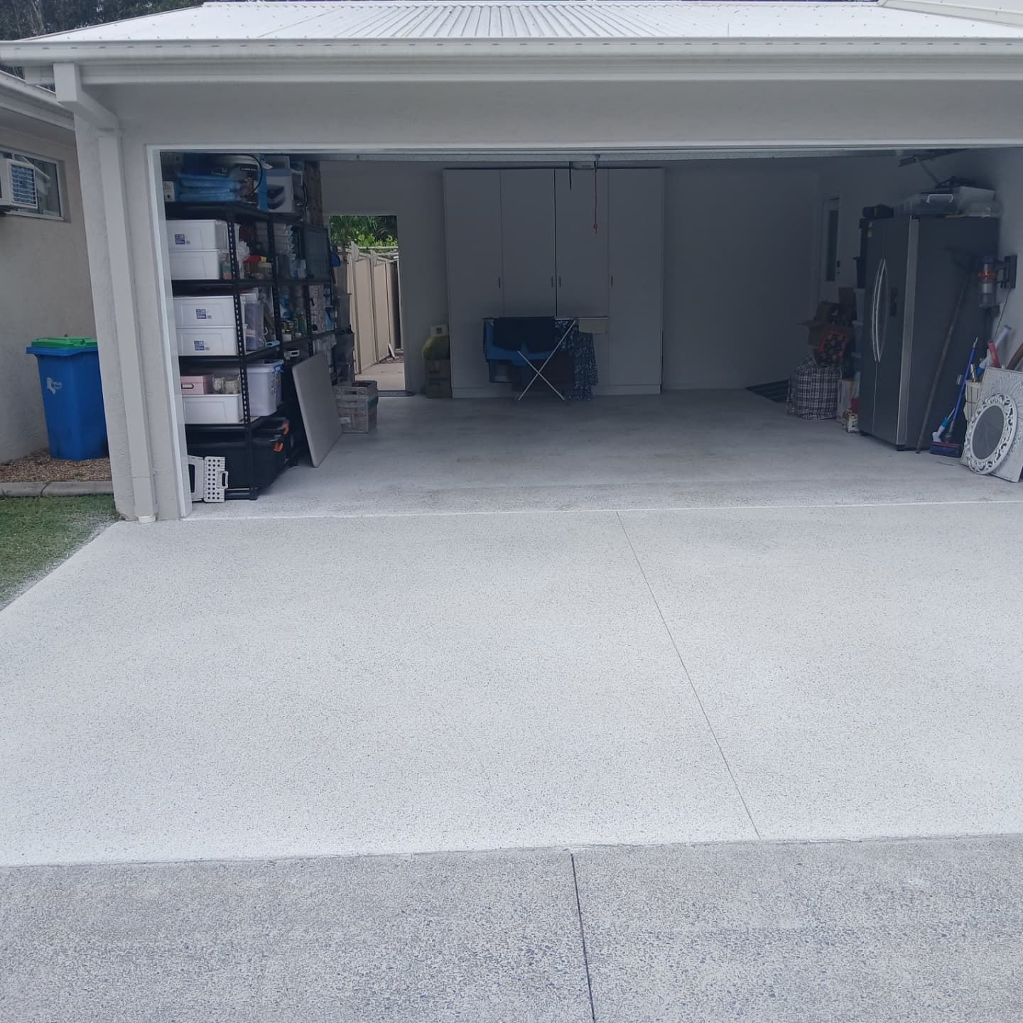 A new driveway in front of a garage — Troys Concrete Overlays in Hillcrest, QLD