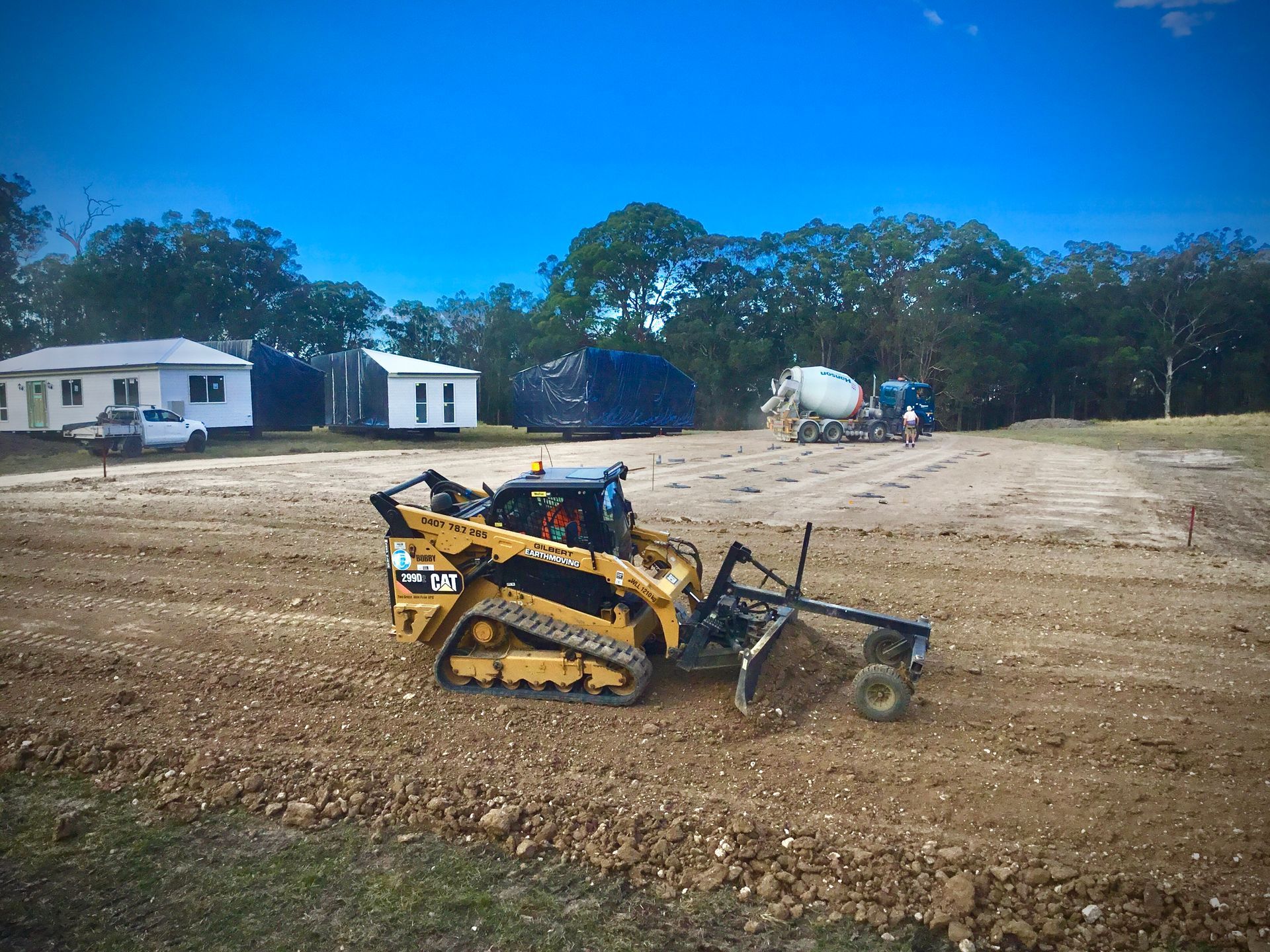 A Large Yellow Excavator is Sitting on Top of a Dirt Field — S M & A J Gilbert Earthmoving in Wingham Island, NSW