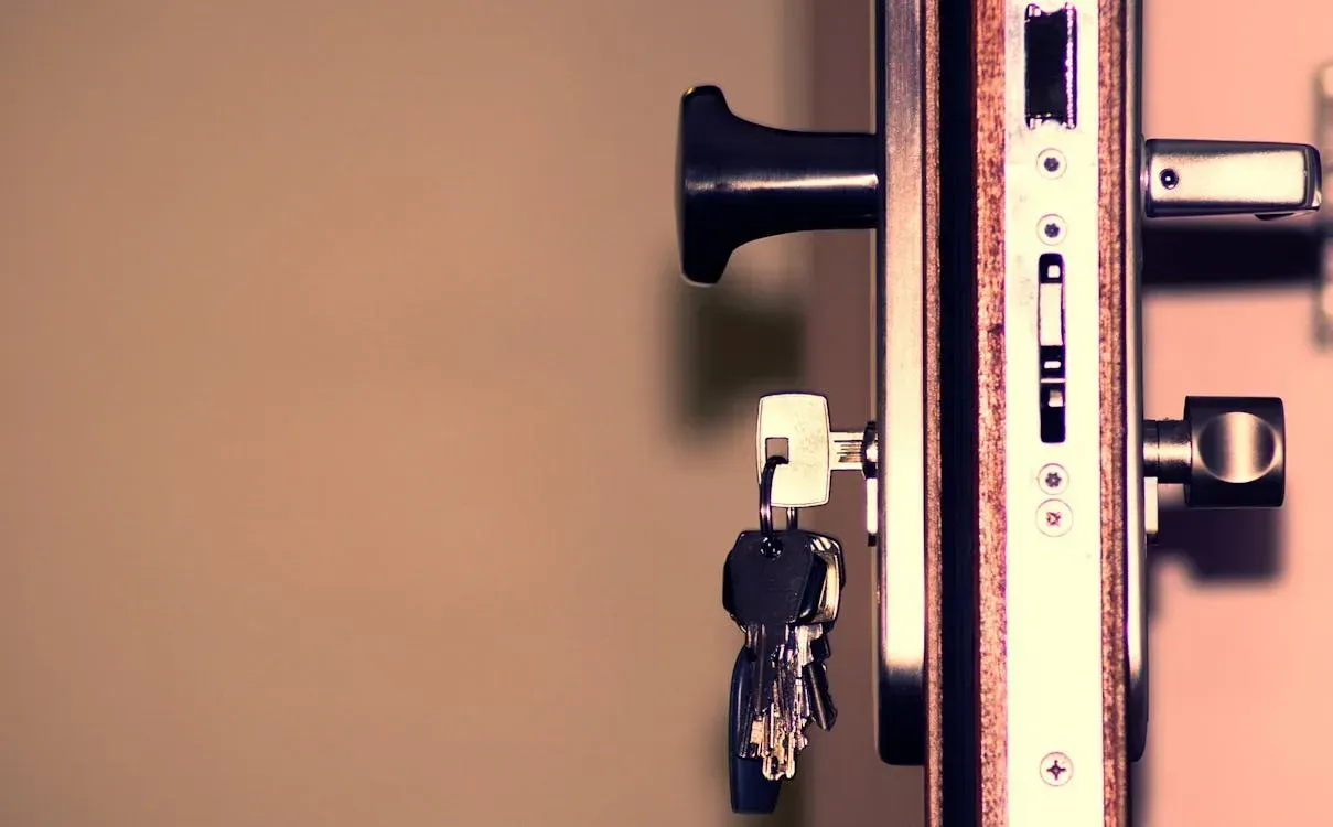 A close up of a door lock with keys in it