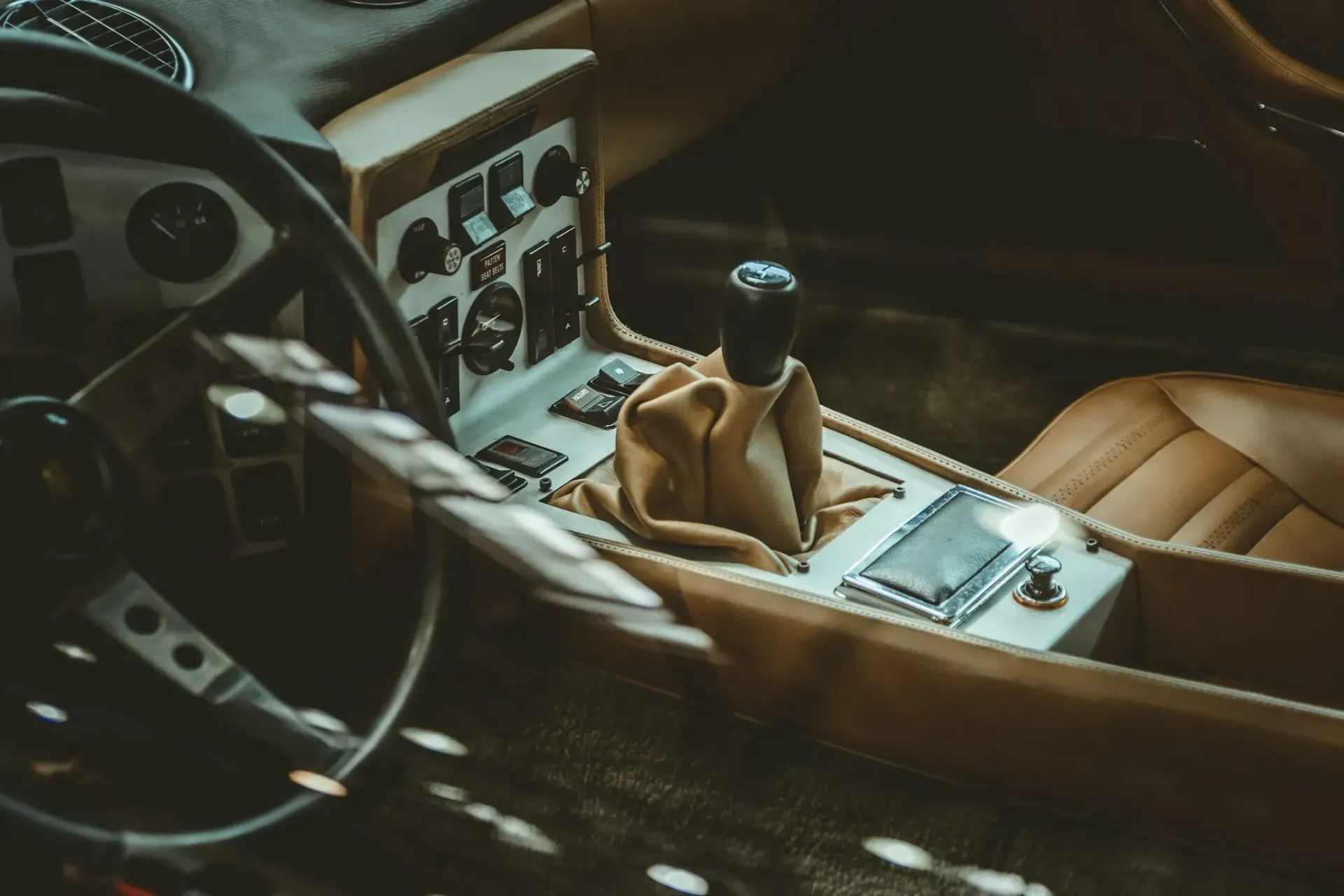 A close up of a car 's steering wheel and shifter