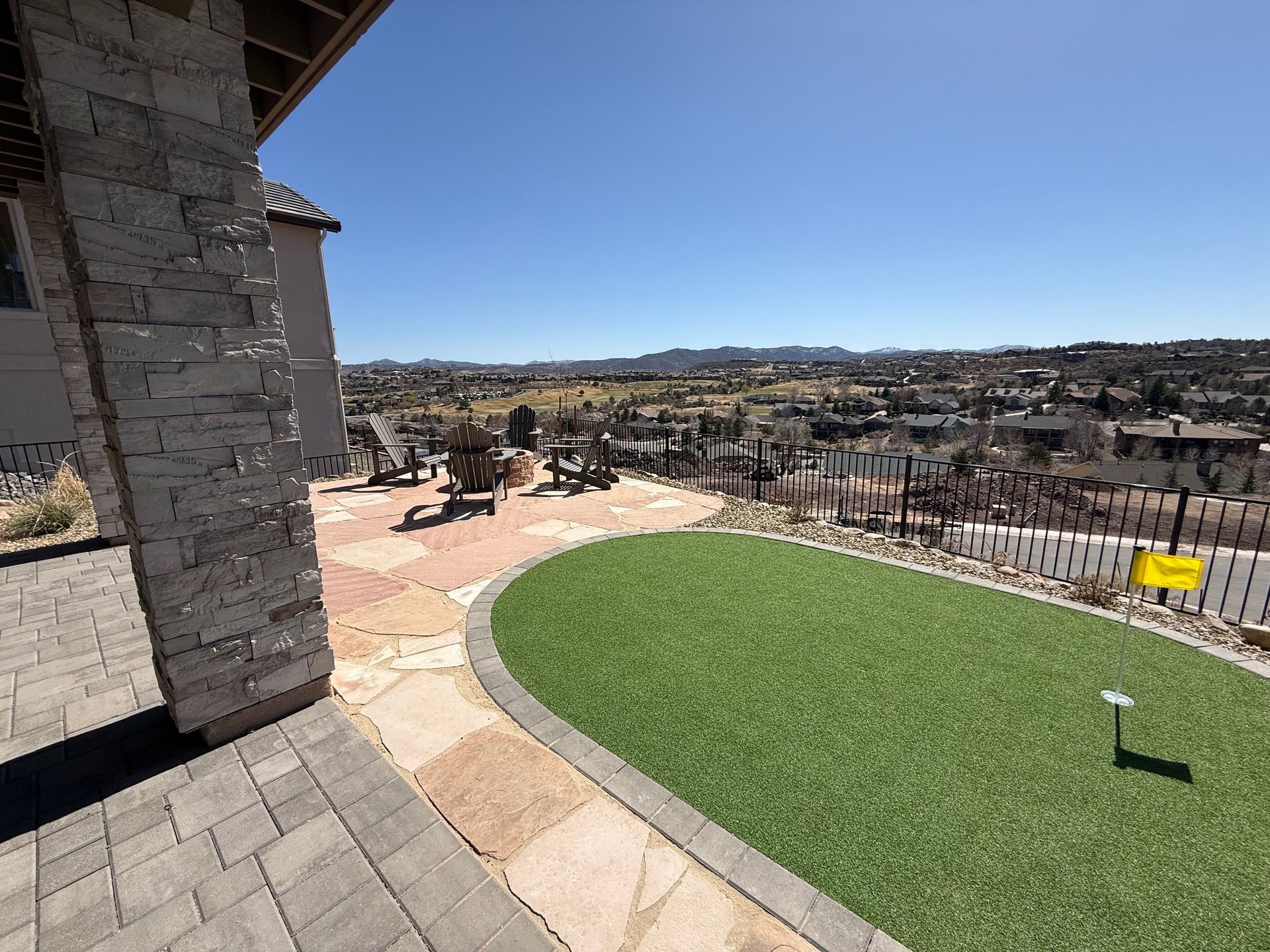 a backyard with stone and artificial turf 