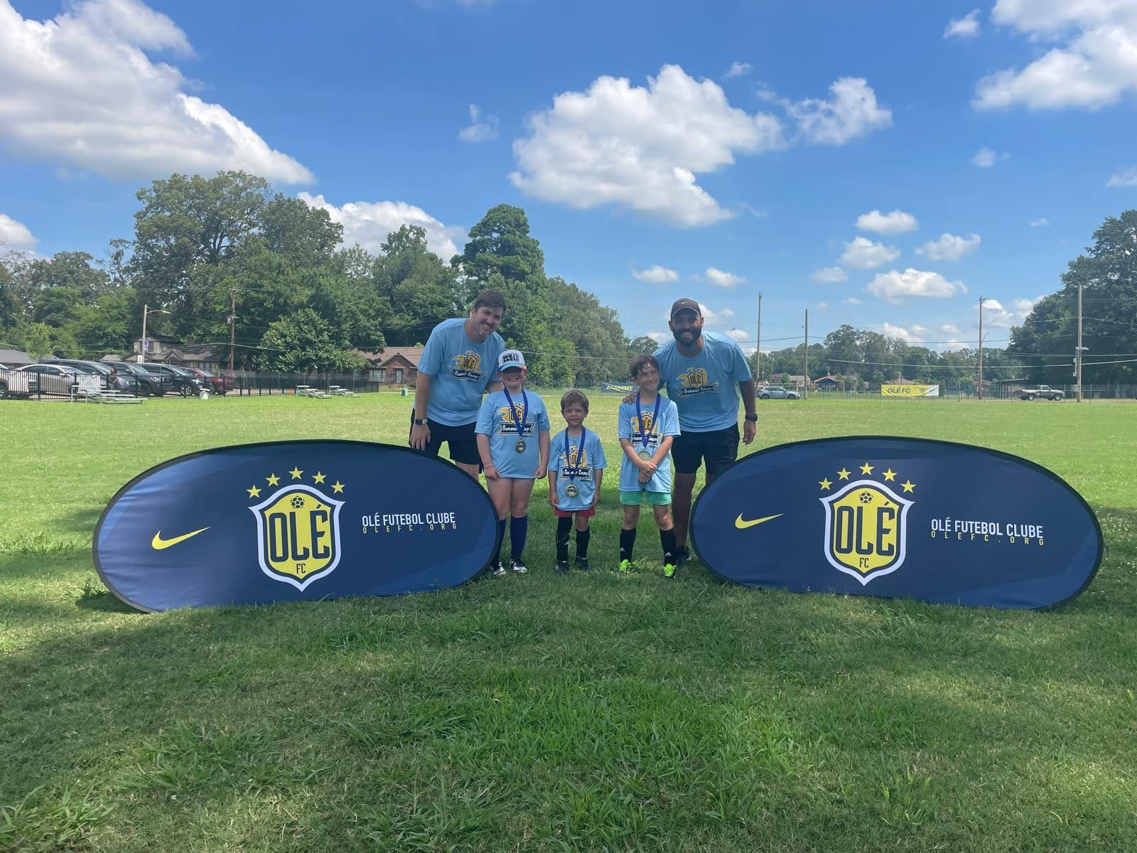 Olé FC children and coaches posing with medals