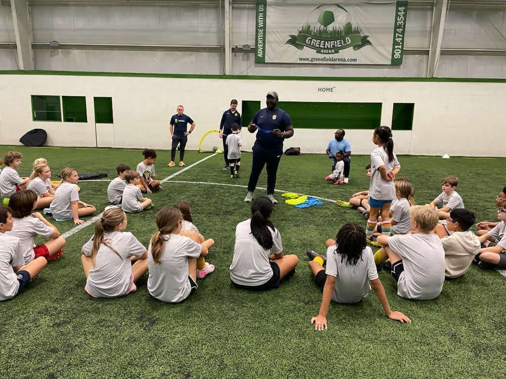 Olé FC Coach speaking to kids in a soccer indoor field at the Winter Break Indoor Clinic
