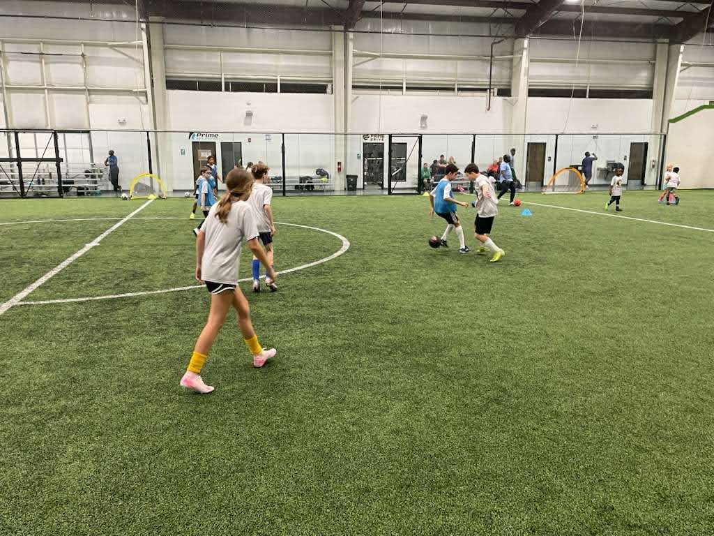 Children playing soccer on an indoor field at the Olé FC Winter Break Indoor Clinic