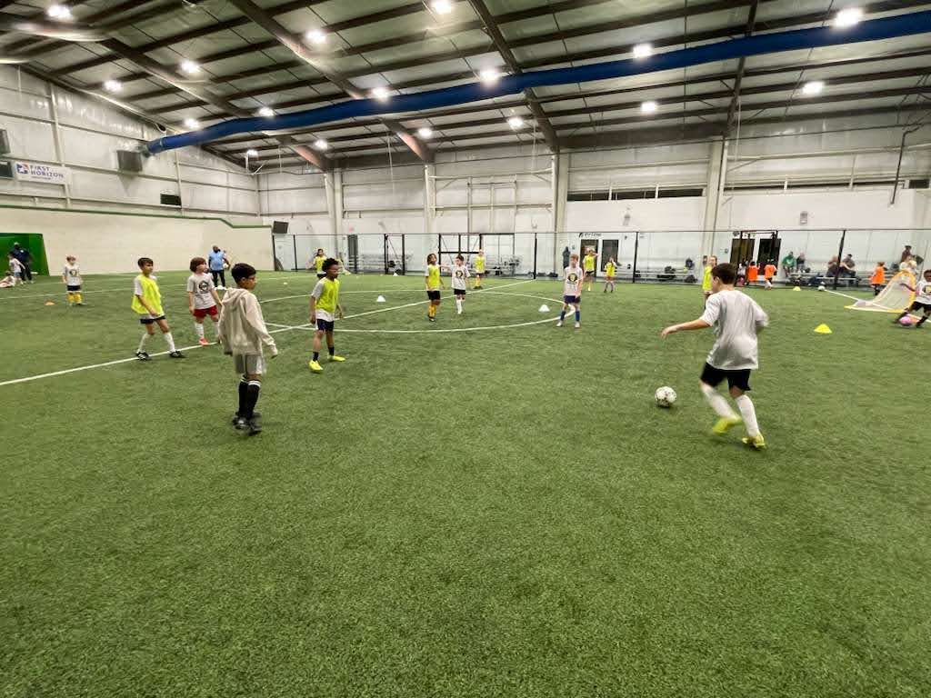 Children playing soccer on an indoor field at the Olé FC Winter Break Indoor Clinic