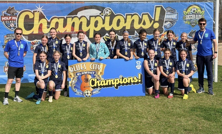 Olé FC team posing with champions banner