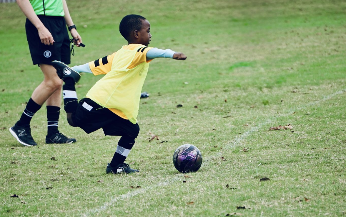 Olé FC youth player kicking the ball