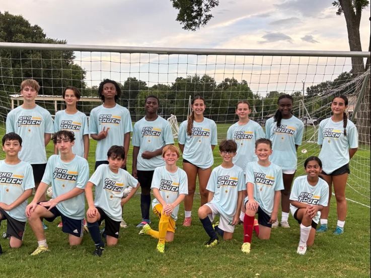 Olé FC soccer team posing in front of a goal