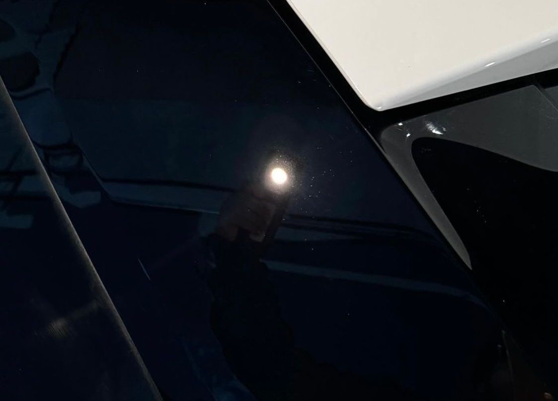 A close up of a car hood with a light on it.