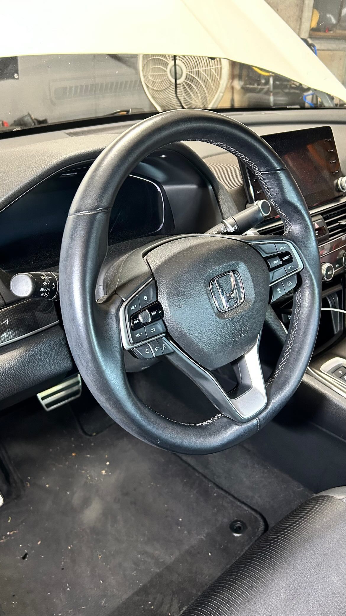 A close up of a steering wheel in a car.