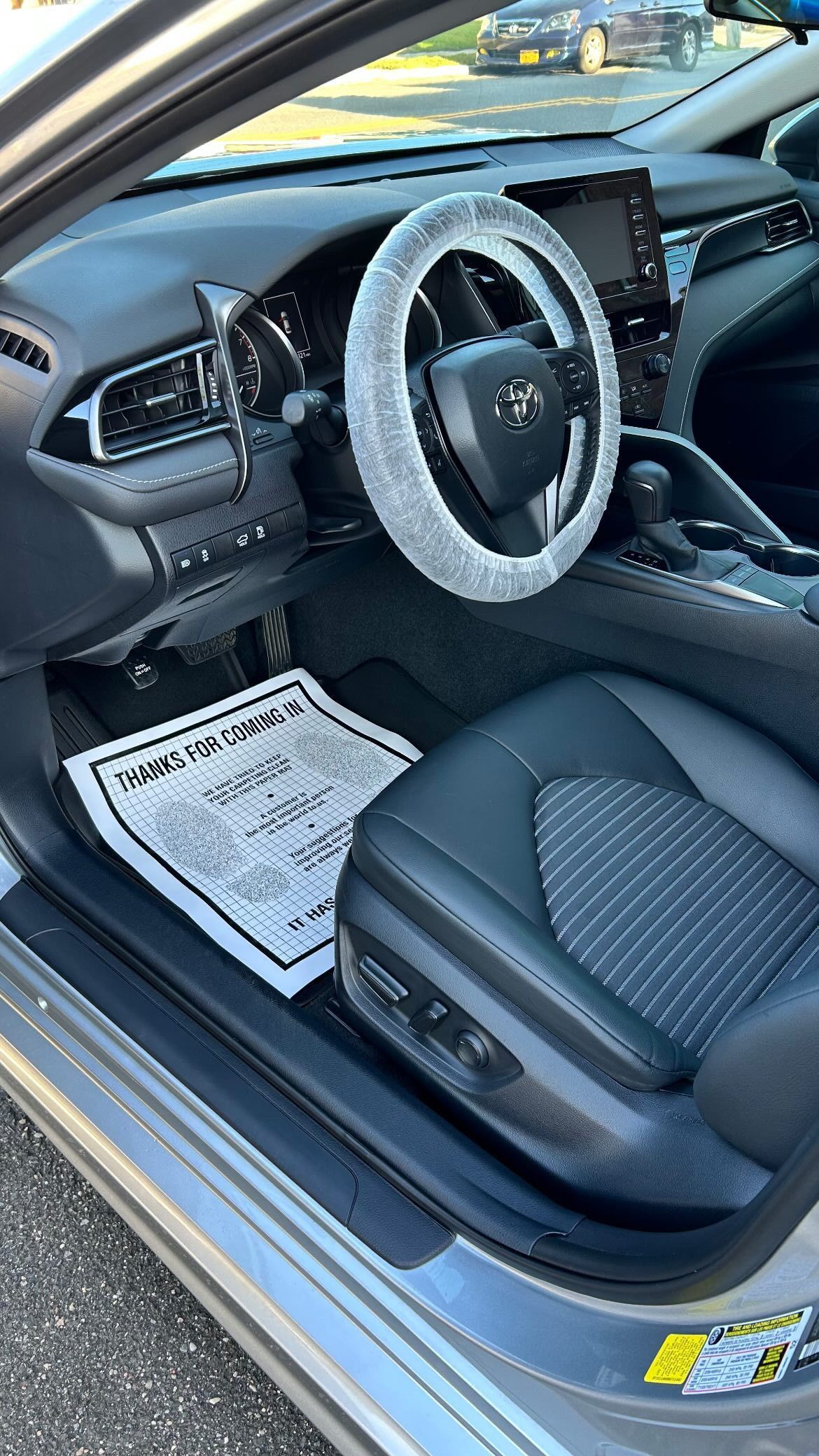 The inside of a car with a steering wheel cover on it.