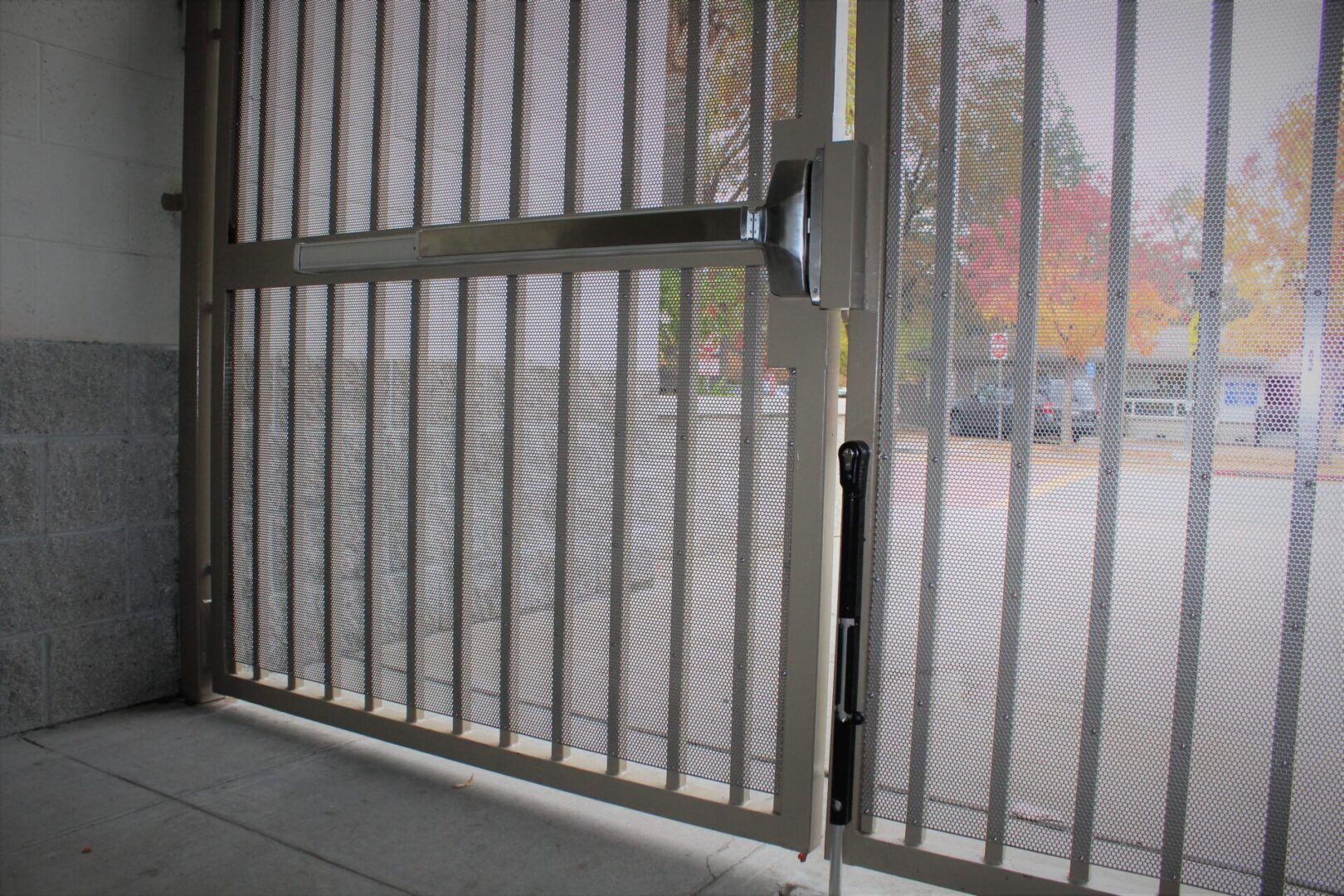 A metal gate is open to a parking lot.