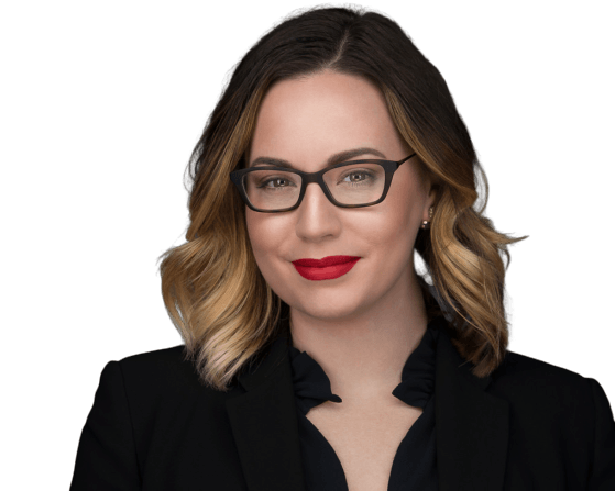 Woman with glasses and red lipstick, wearing a black blazer.