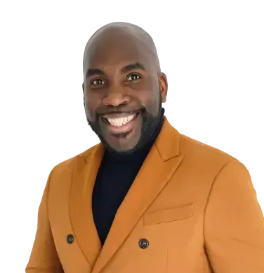 Smiling person wearing an orange blazer and black turtleneck.