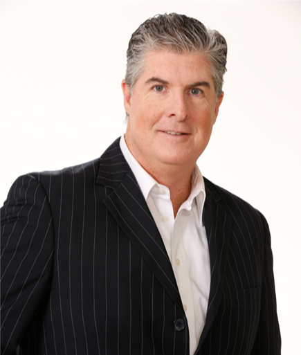 Man in a pinstripe suit, white shirt, smiling.