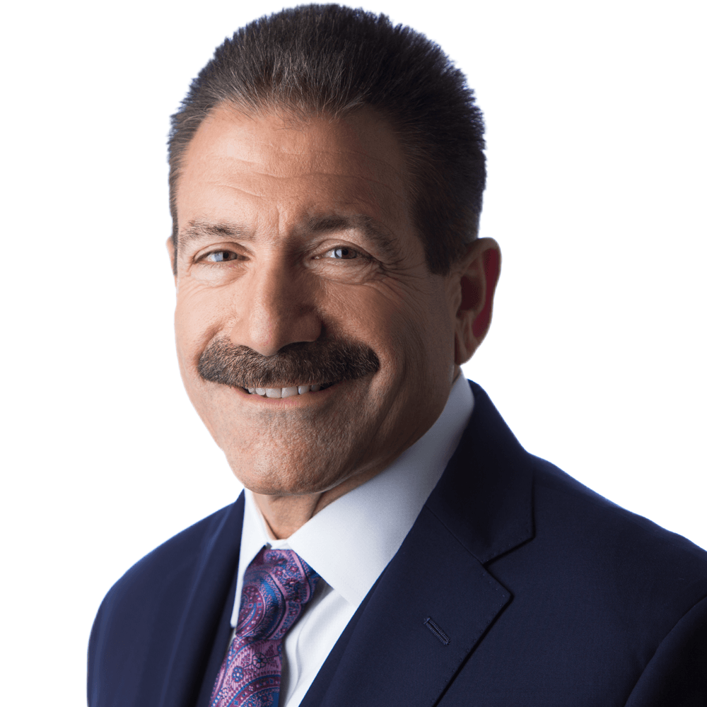 Man in suit with mustache smiling.