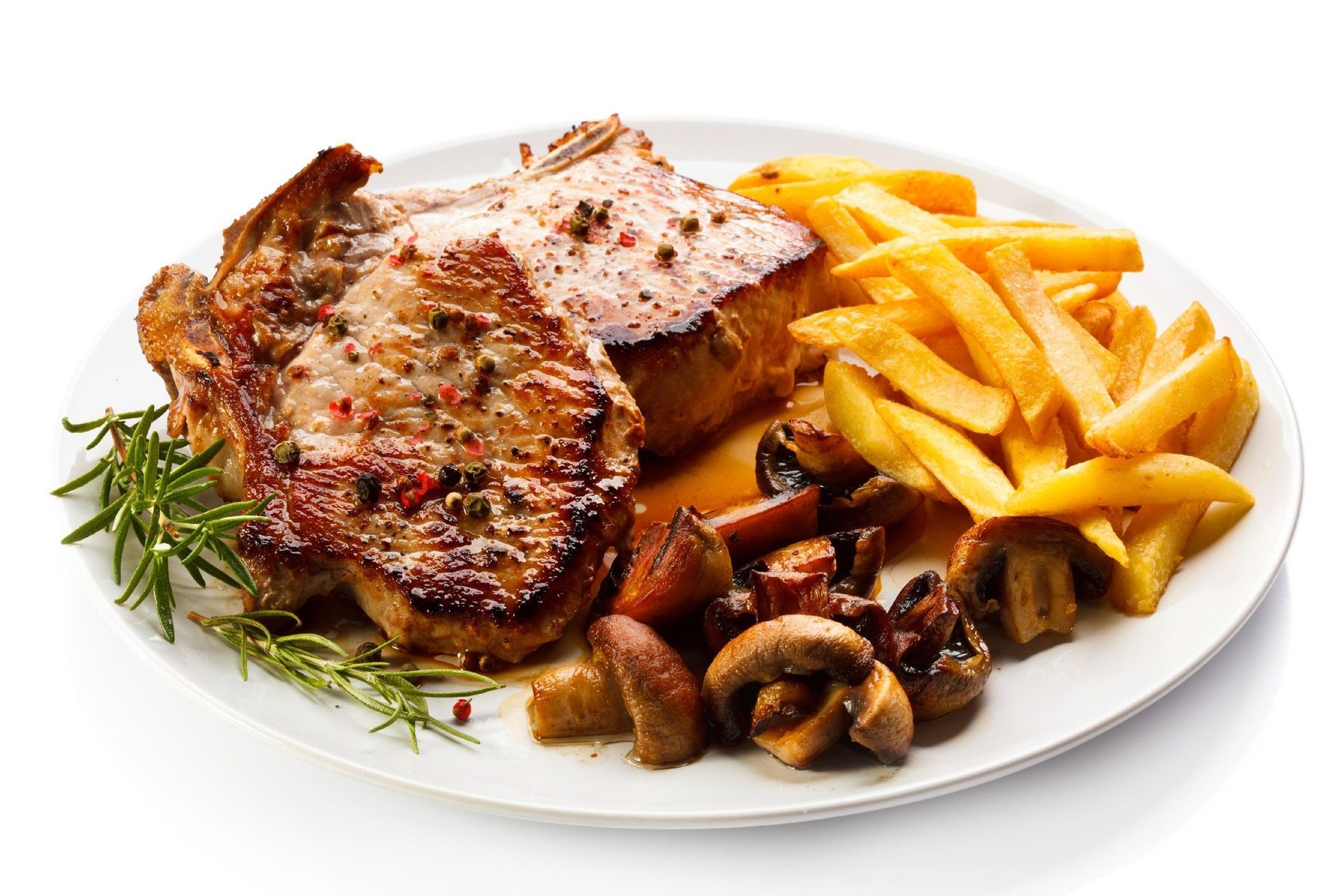 Grilled steak with fries, mushrooms, and herbs on a white plate