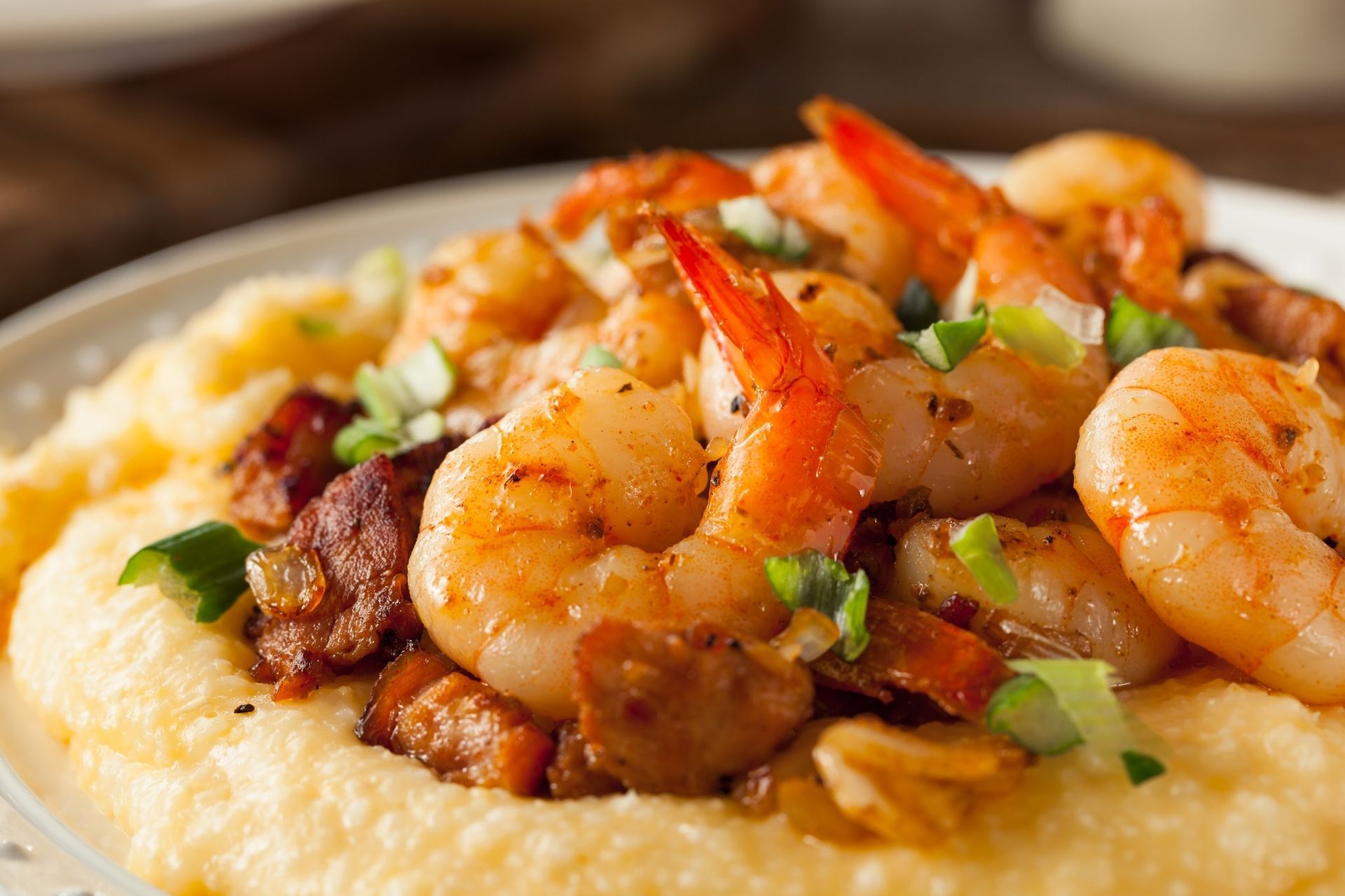 Shrimp and sausage over creamy grits, garnished with chopped green onions