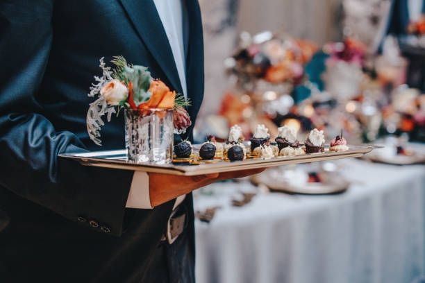Waiter in dark suit carrying a tray of appetizers at a formal event