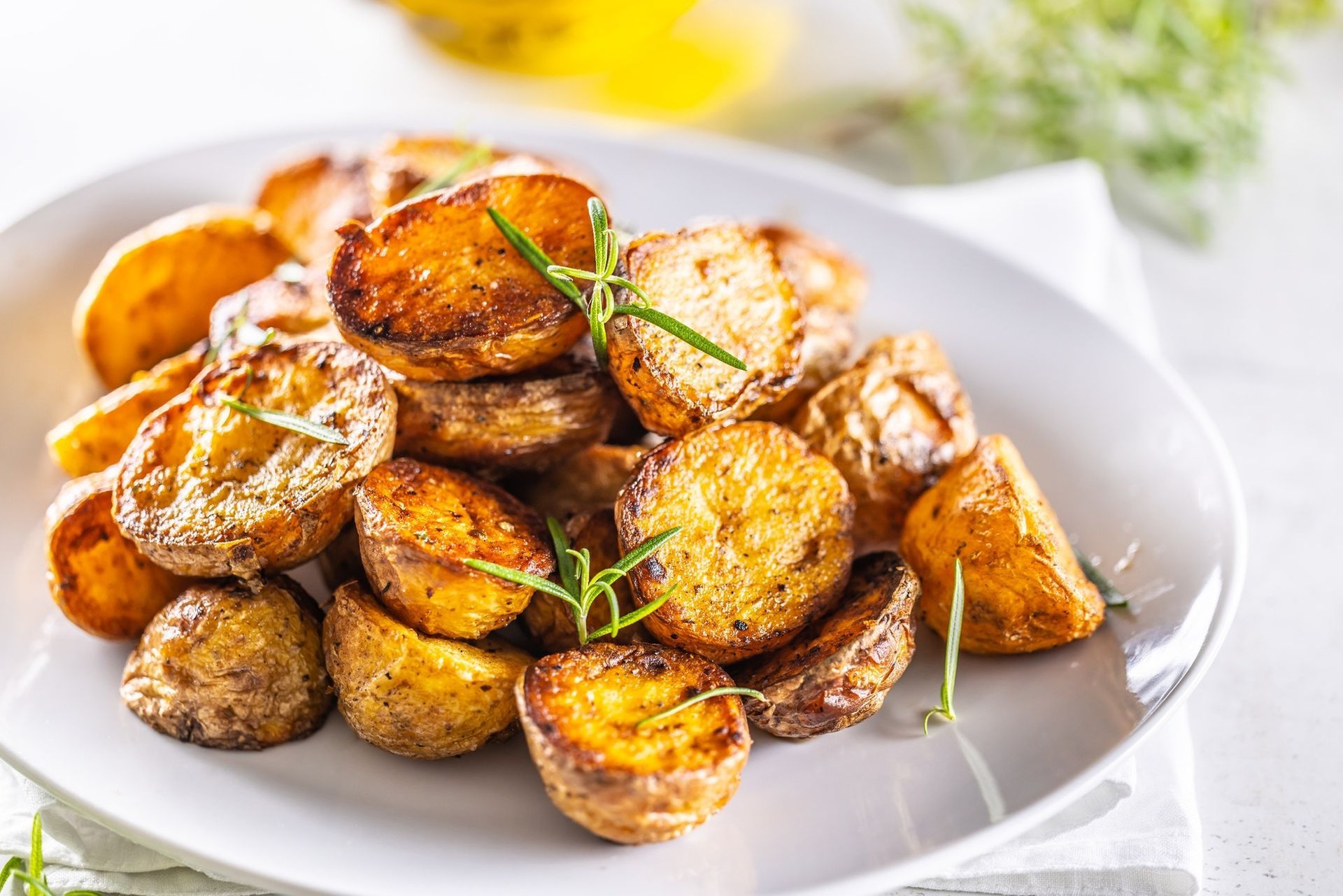 Plate of roasted potato wedges garnished with herbs and spices on a white dish