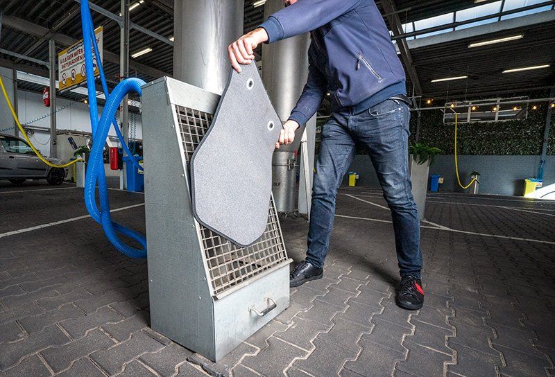 Afbeelding van een persoon die gebruikmaakt van onze mattenklopper